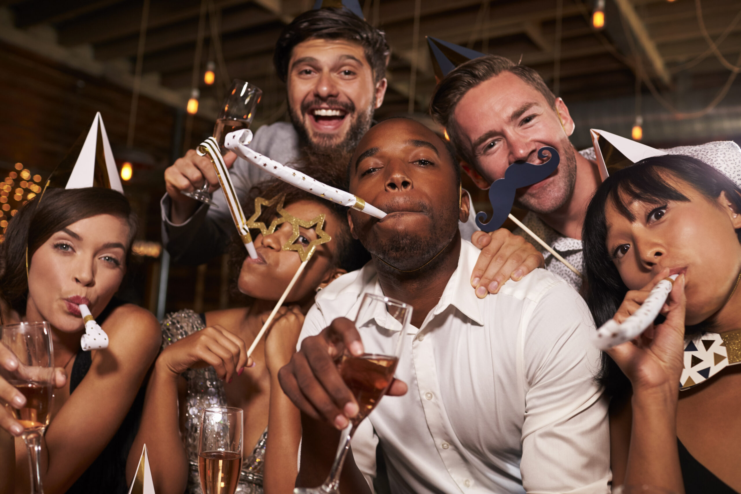 Friends having fun celebrating New Year at a bar, close up
